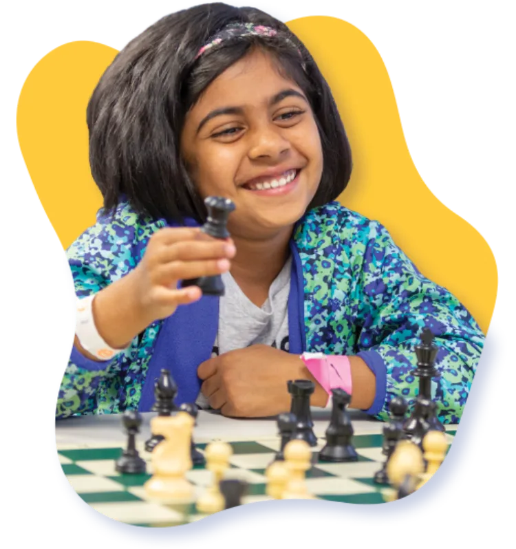 A smiling young chess player at Chess4Life